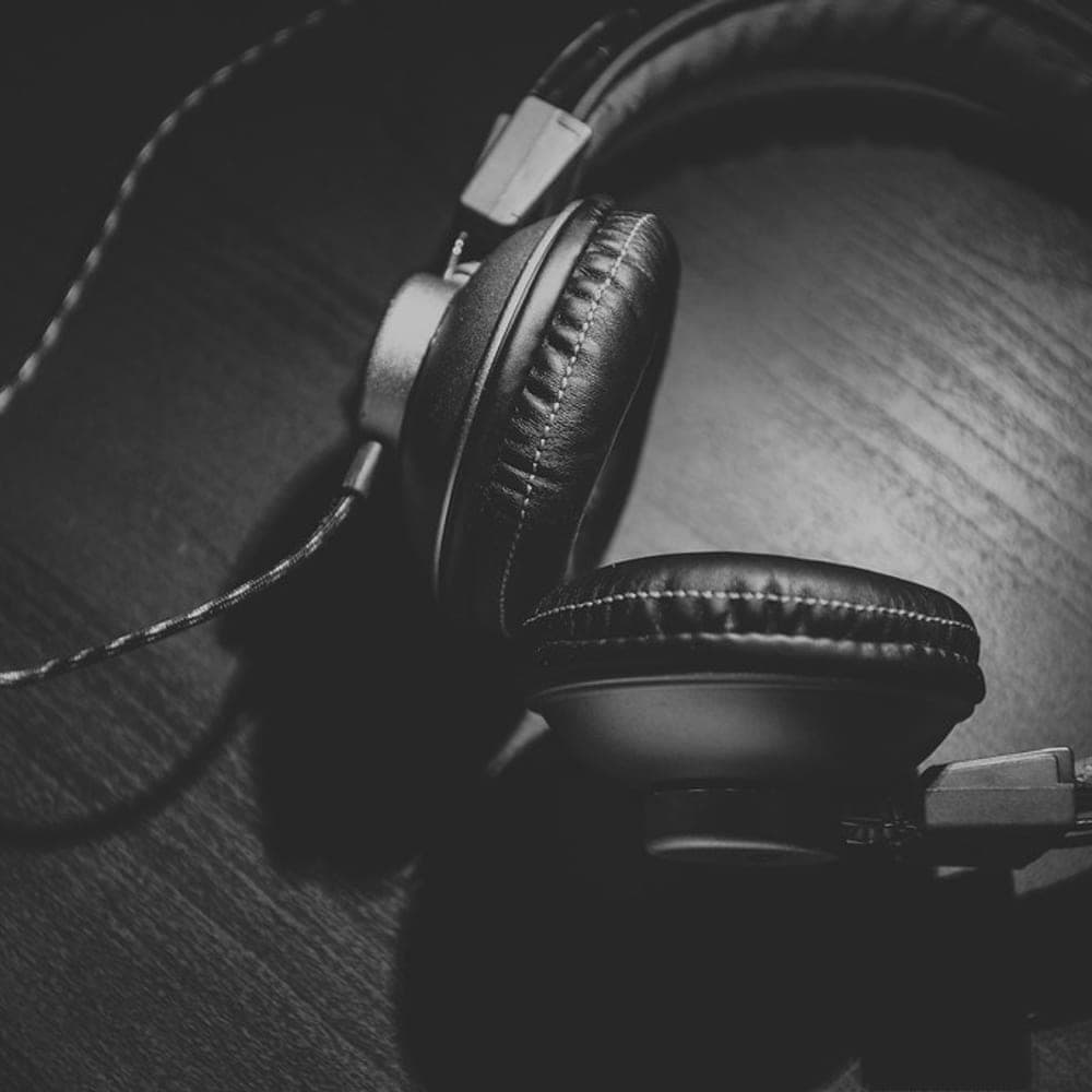 Auriculares over-ear negros apoyados sobre una mesa oscura